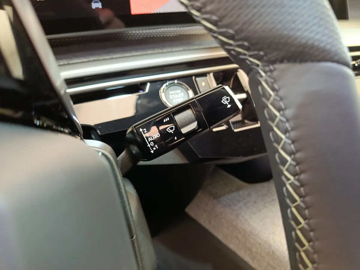 Gros plan sur la commande d'essuie-glace à gauche du volant cuir du Peugeot 3008 gris foncé 2025.