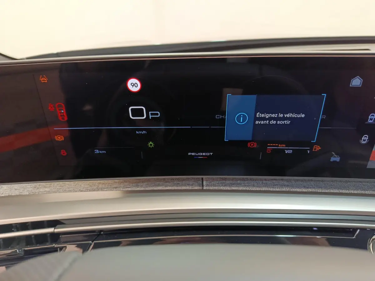 Affichage numérique du tableau de bord du Peugeot 3008 gris foncé, avec message d'alerte et vitesse limitée à 90 km/h.