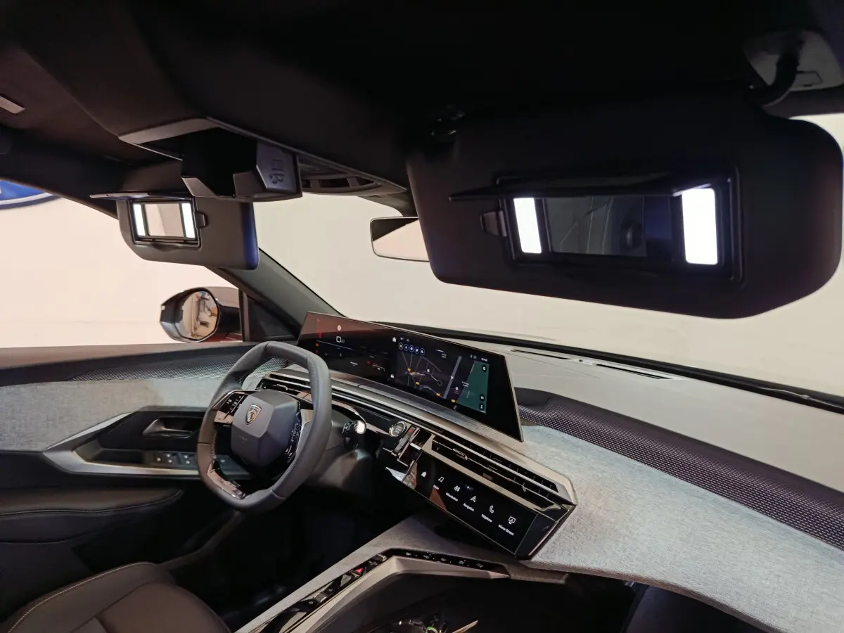 Intérieur du Peugeot 3008 2025 vu côté conducteur, tableau de bord moderne avec écran tactile large et volant cuir noir.