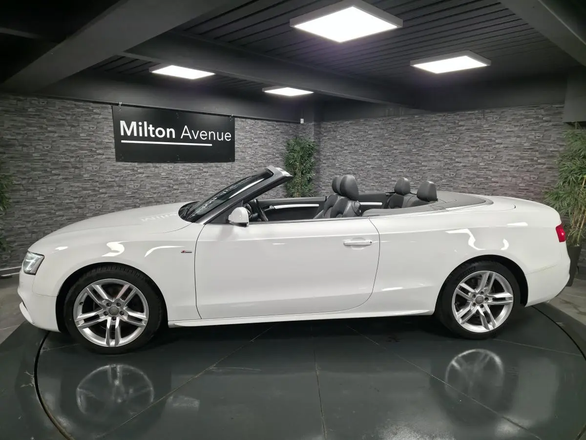Audi A5 Cabriolet blanc vue de profil côté gauche, capote ouverte et jantes aluminium sport 5 branches doubles