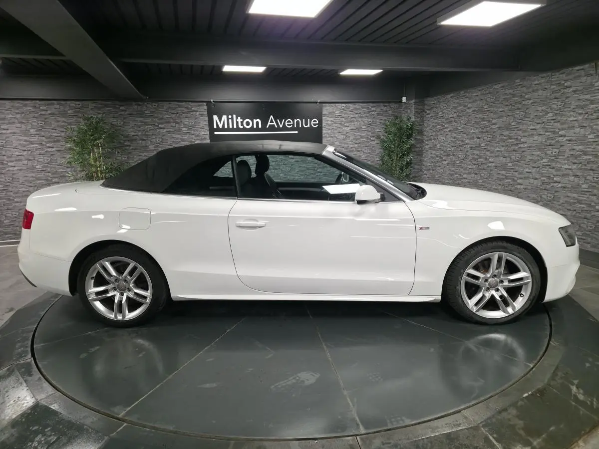Audi A5 Cabriolet blanc vue de profil côté gauche avec capote noire et jantes aluminium sport 5 branches doubles