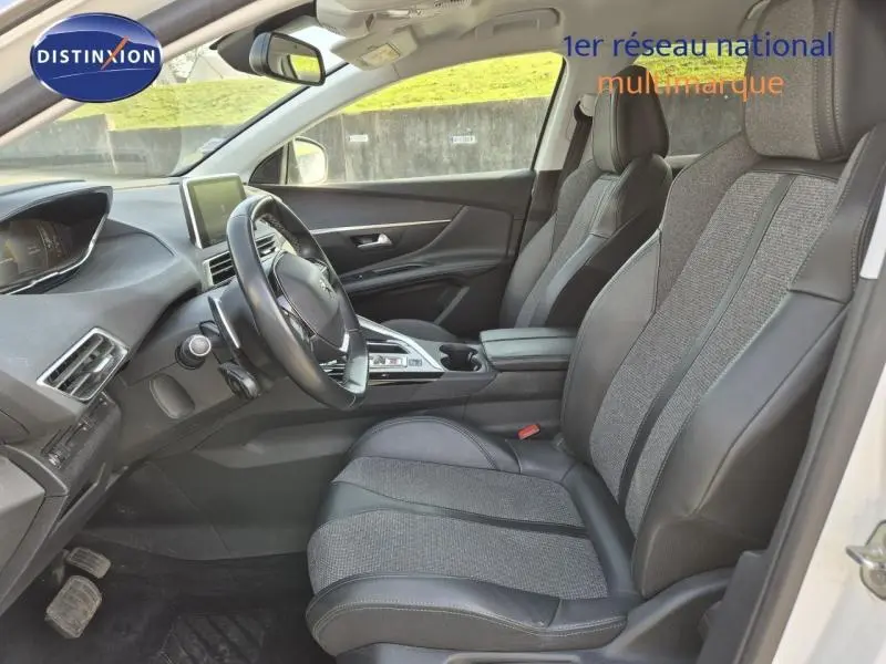 Vue intérieure côté conducteur du Peugeot 3008 blanc nacré, sièges tissu et cuir avec console centrale moderne.
