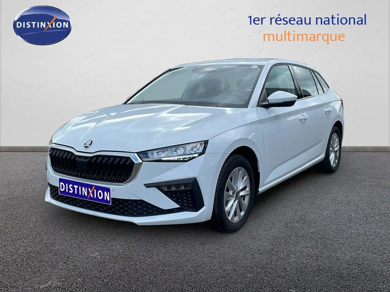 Skoda Scala blanc glacier vue 3/4 avant droit, mettant en valeur sa calandre noire et ses optiques fines.