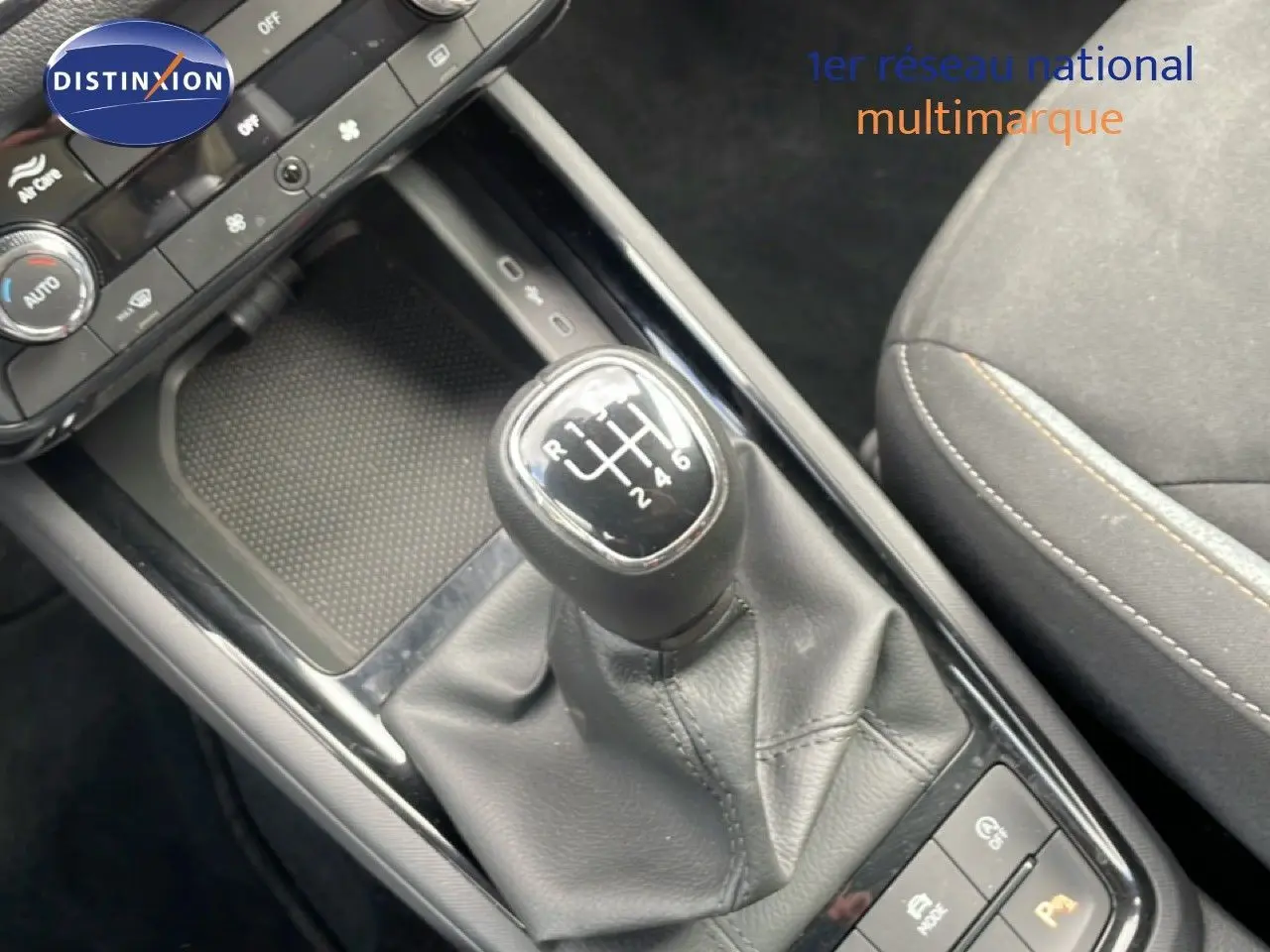 Gros plan sur le levier de vitesses manuel de la Skoda Scala 2025, intérieur tissu gris noir avec console centrale noire brillante.