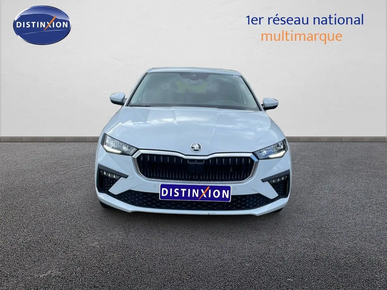 Vue frontale d'une Skoda Scala blanc glacier avec calandre noire et phares LED allumés.