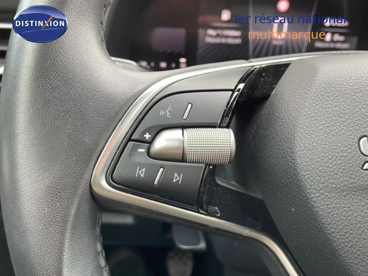 Gros plan sur les commandes multifonctions au volant d’une Skoda Scala 2025, finition tissu gris-noir.