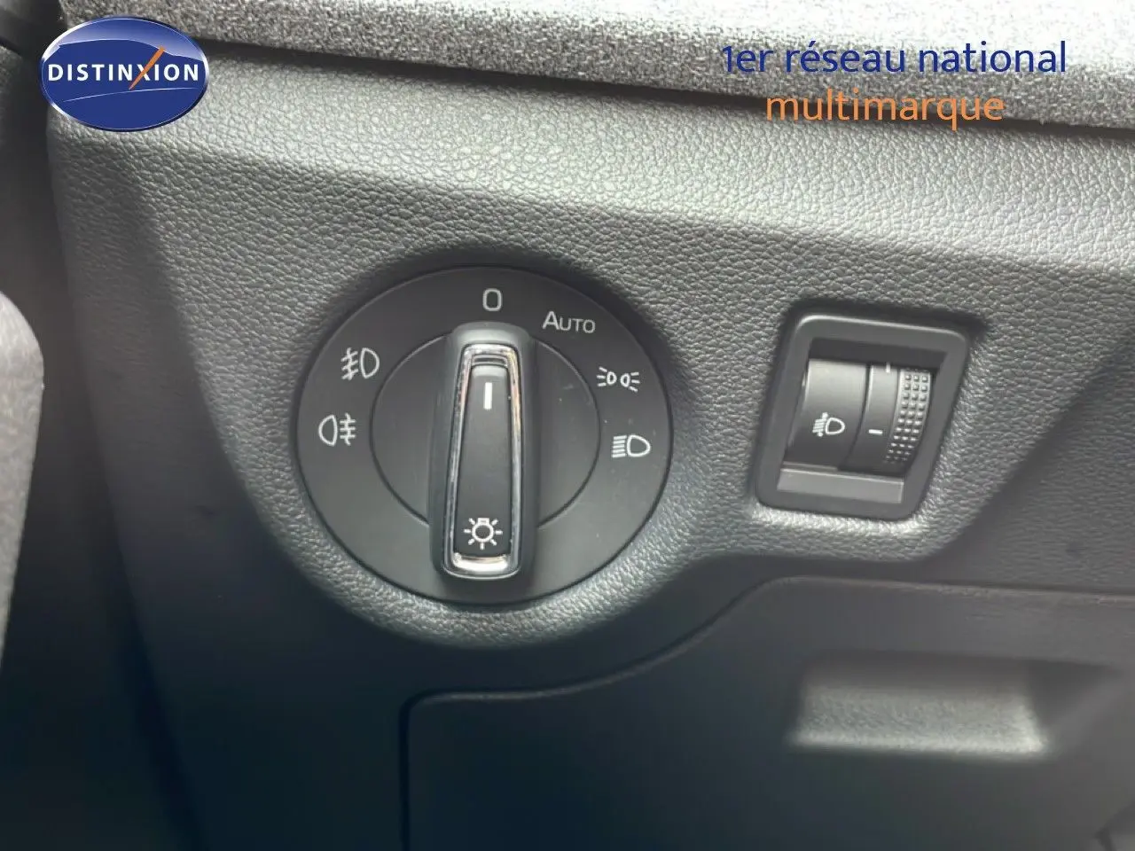 Gros plan sur le bouton de commande des phares dans l’habitacle d’une Skoda Scala blanc glacier 2025.