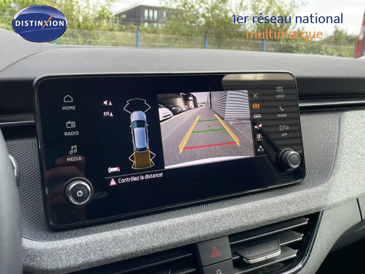 Écran central de la Skoda Scala blanc glacier 2025 montrant la caméra de recul avec guidage de trajectoire.