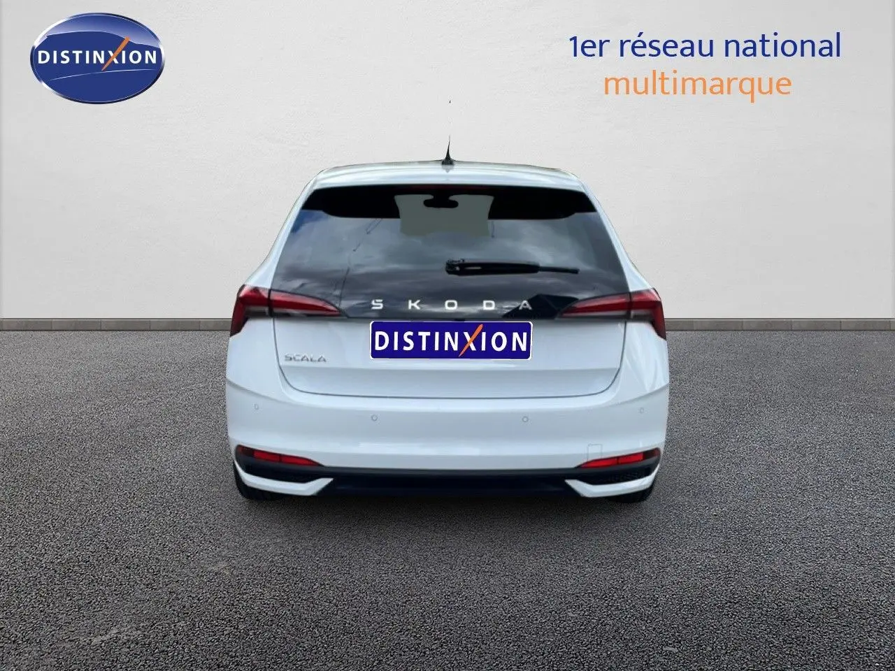 Vue arrière d'une Skoda Scala blanc glacier, avec feux arrière étirés et logo SKODA visible sur le hayon.