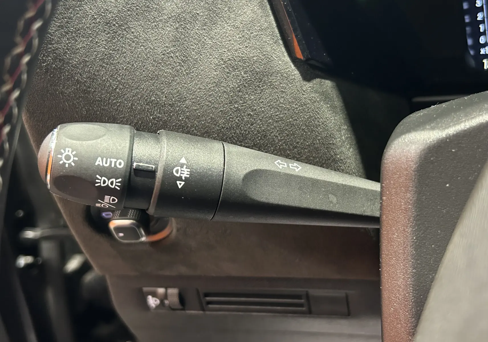 Gros plan sur la commande des phares et clignotants à gauche du volant d'une DS4 2024 noir Perla Nera.