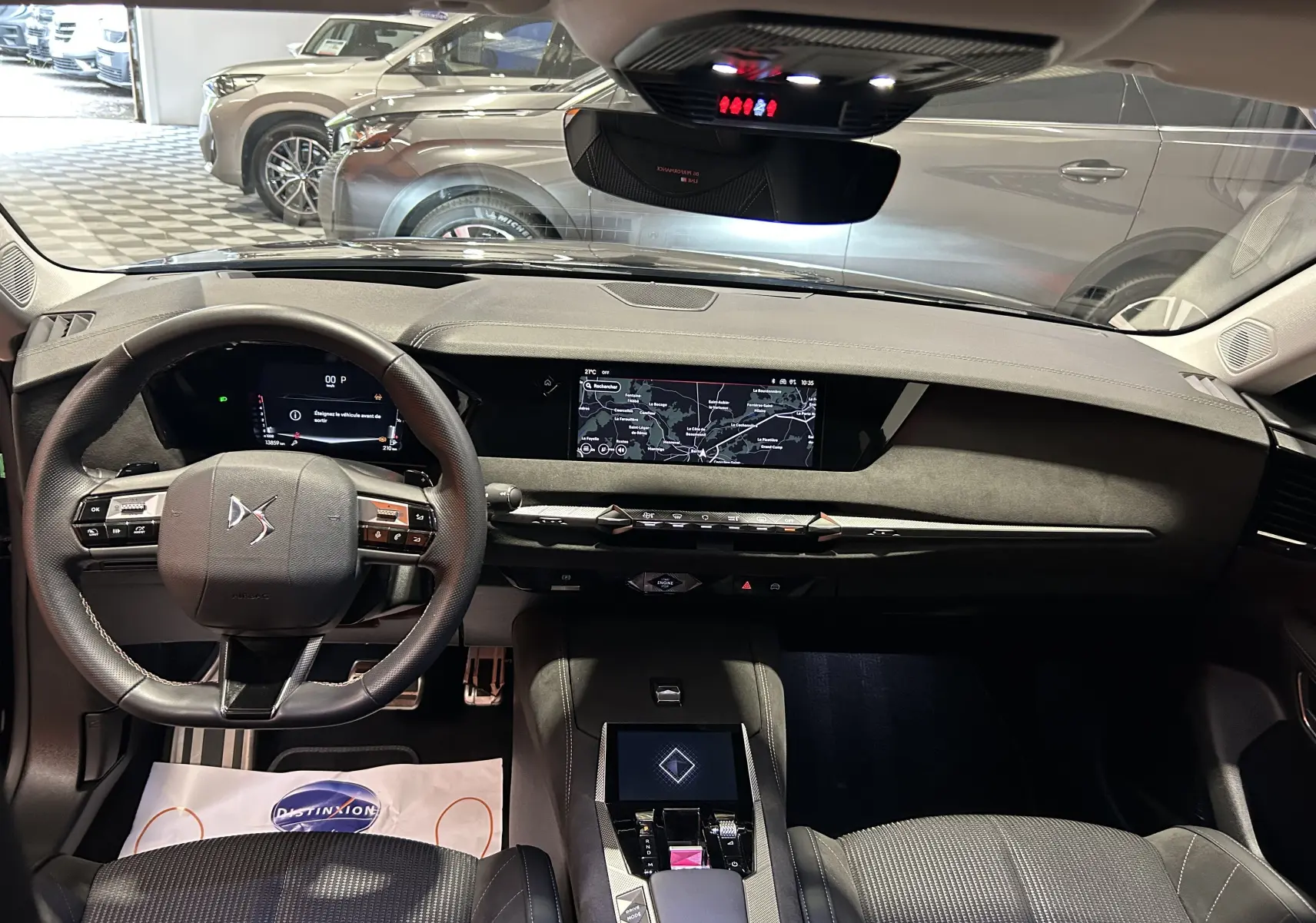 Intérieur du DS4 2024 en noir, vue de face sur le tableau de bord avec écran GPS et volant multifonction.