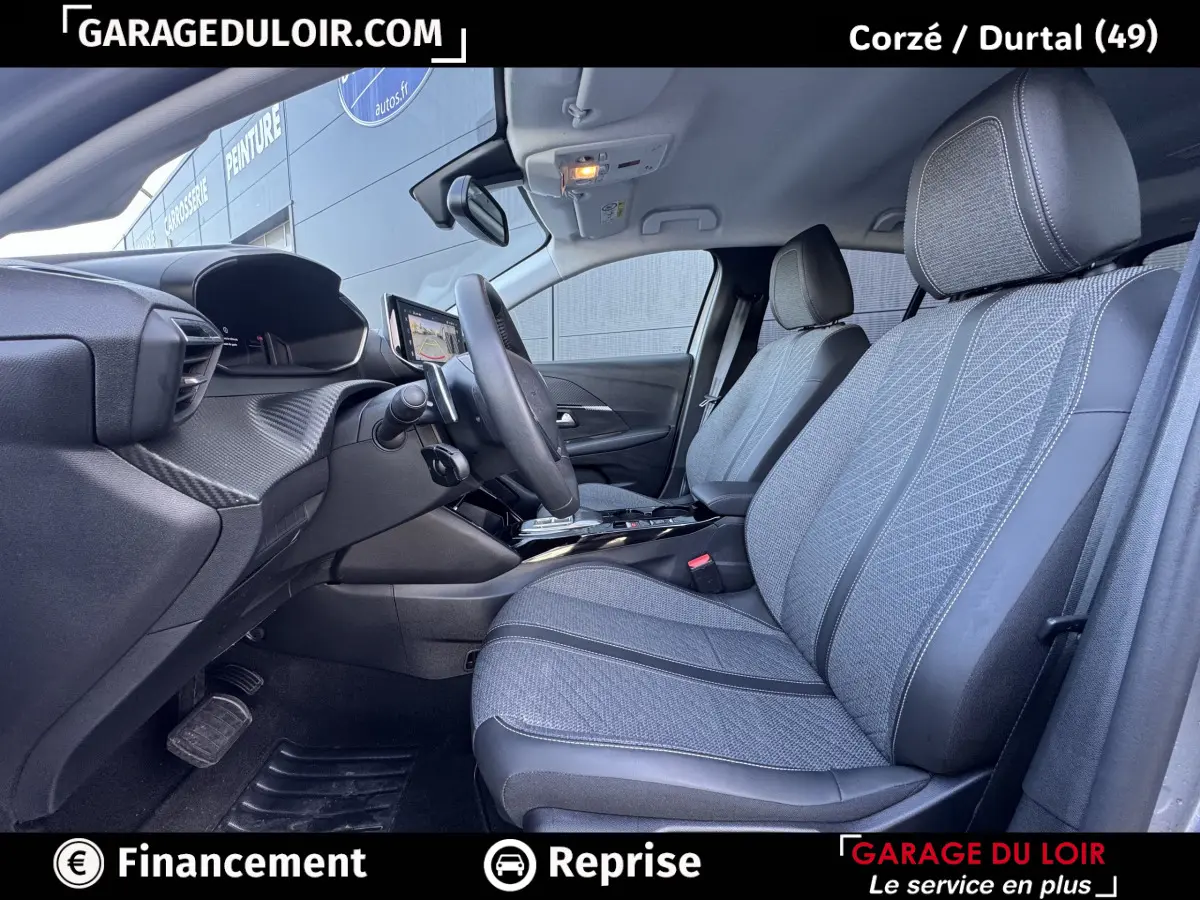 Vue intérieure côté conducteur de la Peugeot 208 Hybrid 110 Allure avec sièges tissu gris et tableau de bord moderne.
