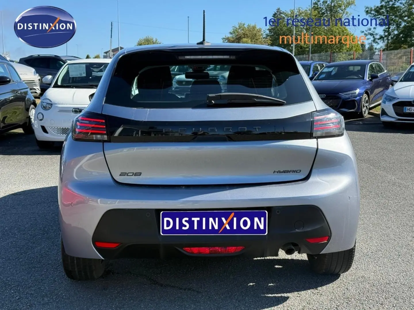 Vue arrière d'une Peugeot 208 hybride gris Artense avec feux LED et logo noir brillant sur le hayon.