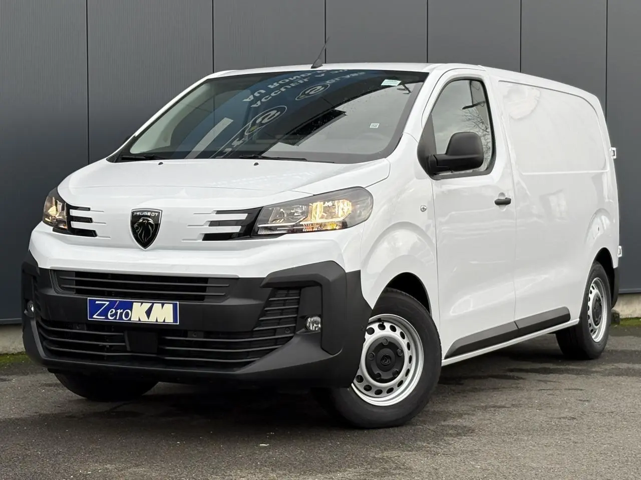 Vue 3/4 avant droit du Peugeot Expert Fourgon blanc Icy avec pare-chocs noirs et roues tôles grises.