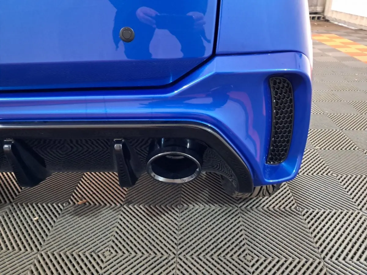 Gros plan sur l'arrière droit bleu de l'AIXAM AMBITION 2025, mettant en valeur la sortie d'échappement et le diffuseur noir.