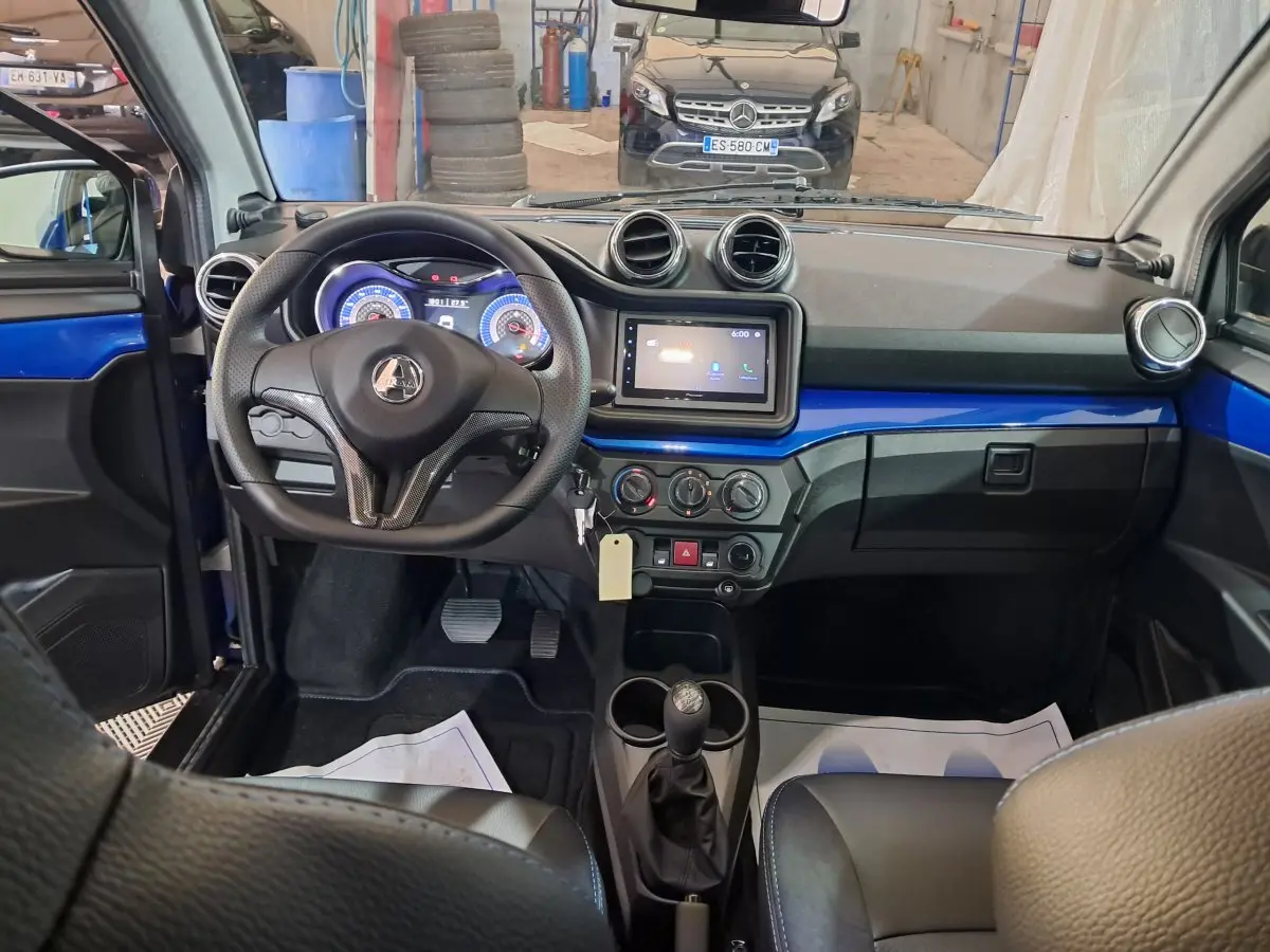 Vue intérieure de l'AIXAM AMBITION 2025 bleu, tableau de bord avec écran tactile et volant multifonction.