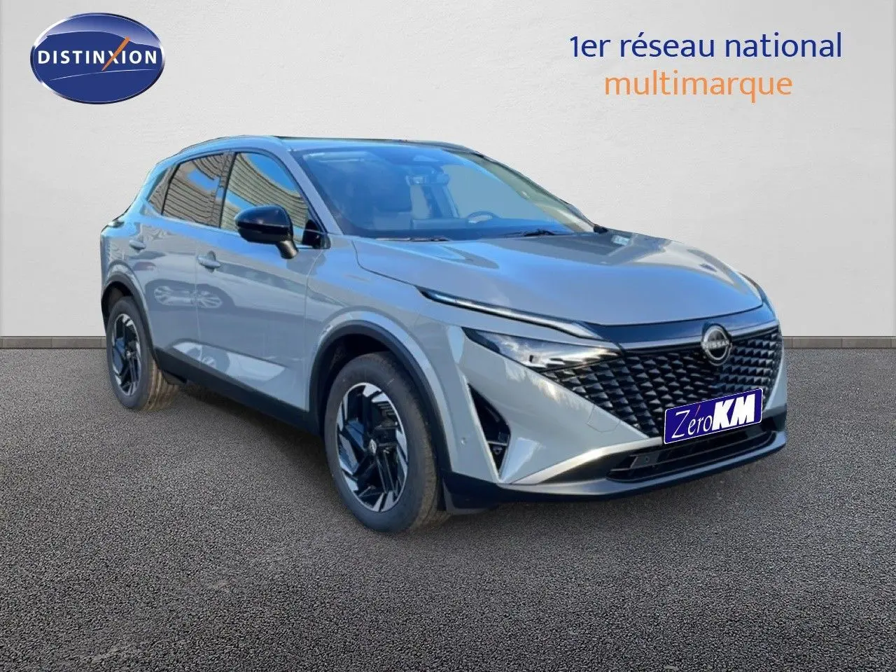 Nissan Qashqai 1.5 E-POWER gris argile métal en 3/4 avant droit, avec calandre noire et jantes stylisées.