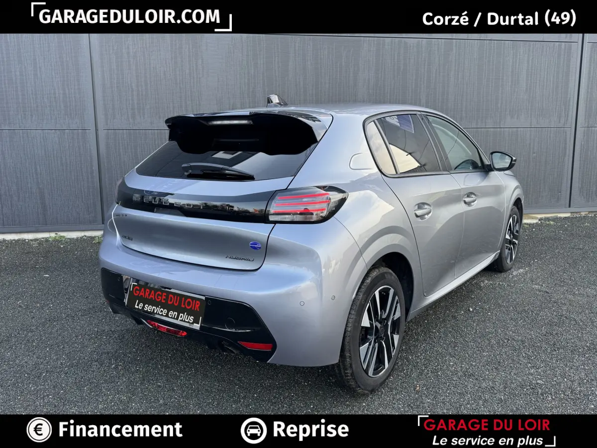 Vue 3/4 arrière droite d'une Peugeot 208 Hybrid gris clair avec feux arrière LED et jantes alliage noires.