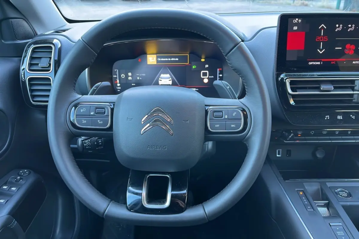Vue frontale du volant cuir multifonctions et tableau de bord numérique du Citroën C5 Aircross Hybrid 145 blanc.