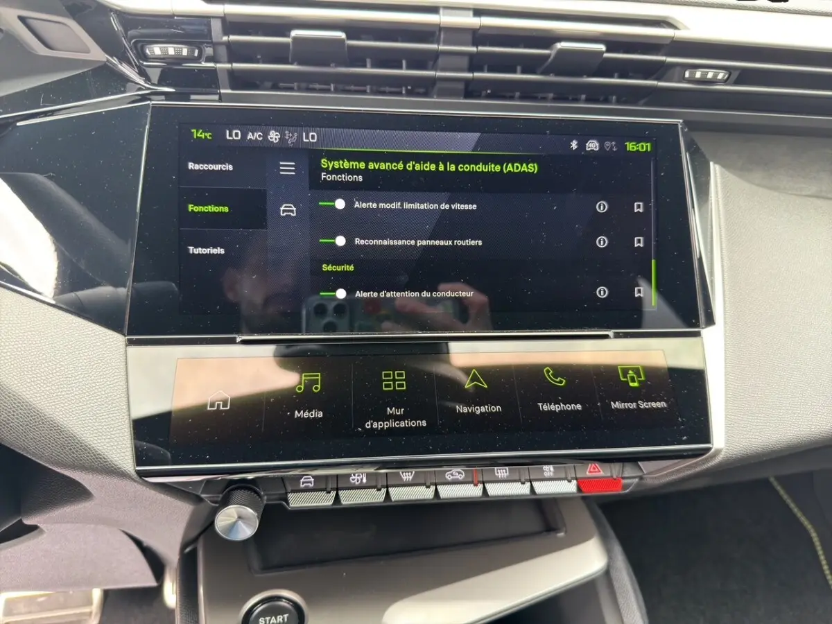 Vue rapprochée de l’écran tactile central affichant le système d’aide à la conduite dans l’habitacle d’une Peugeot 308 gris clair.