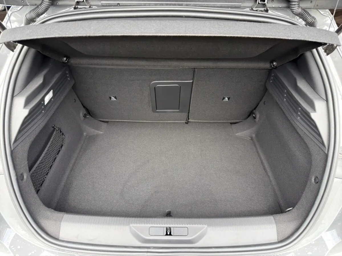 Coffre ouvert de la Peugeot 308 gris clair, vue plongeante montrant un espace de rangement propre et spacieux.