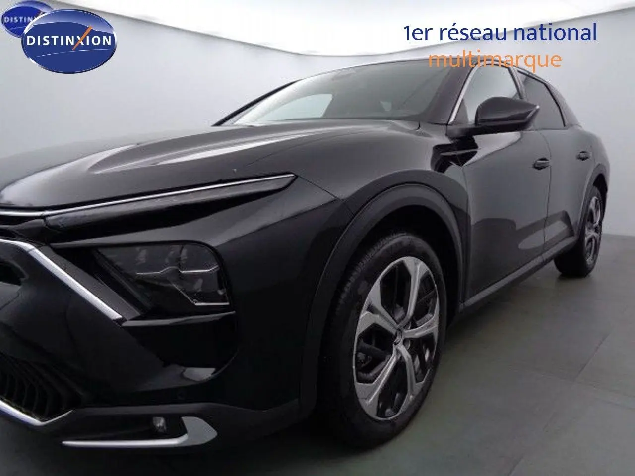 Citroën C5 X noir métal vue 3/4 avant droit, mettant en valeur ses phares fins et ses jantes alliage modernes.