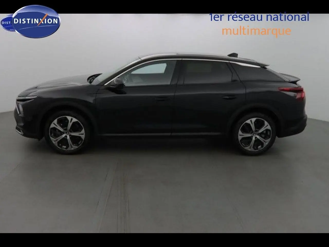 Profil latéral droit d'une Citroën C5 X noire métal 2022 avec jantes alliage et toit surélevé élégant.