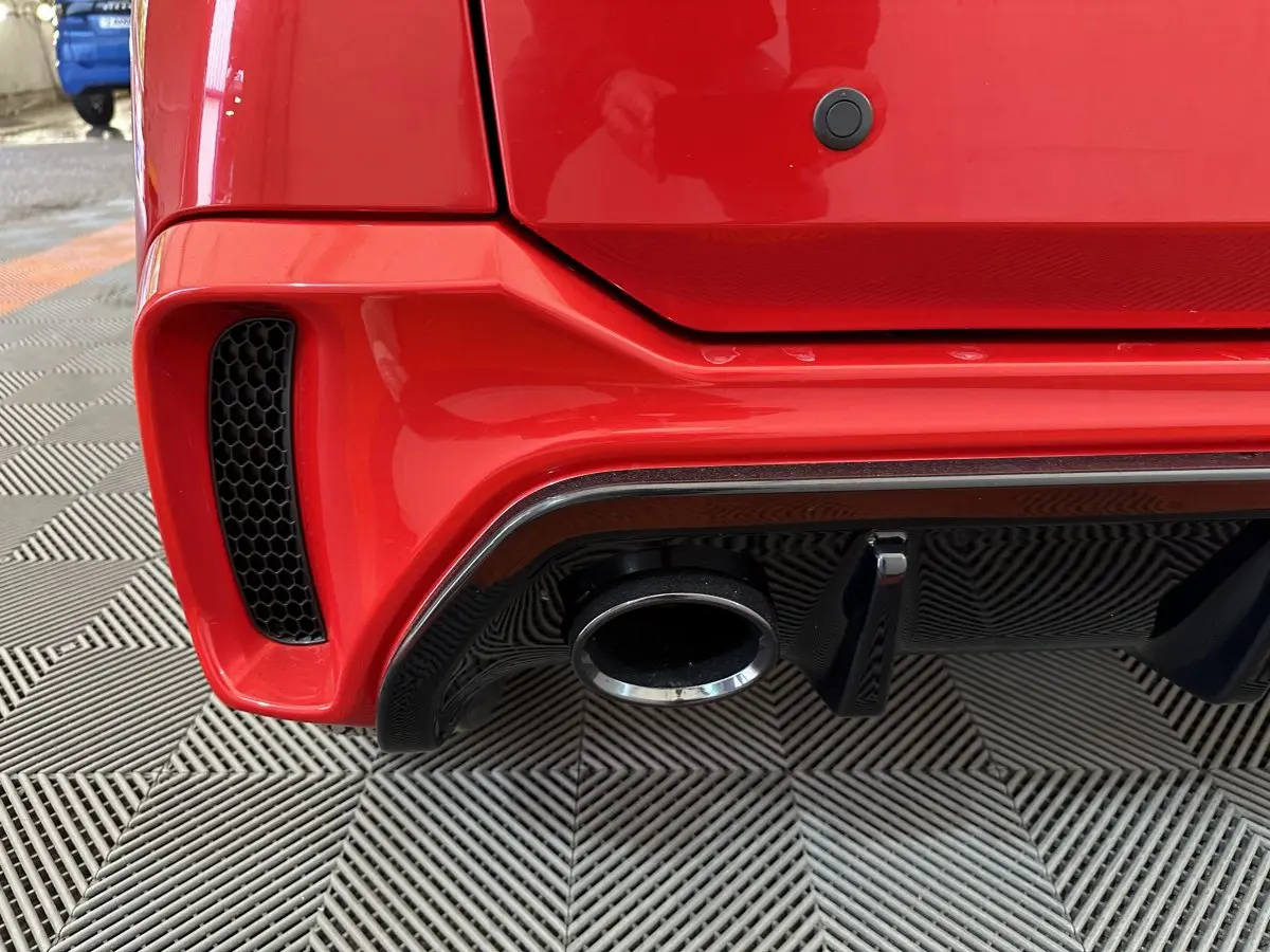 Gros plan sur le pot d’échappement et le diffuseur arrière noir d’une Aixam Ambition rouge côté gauche.