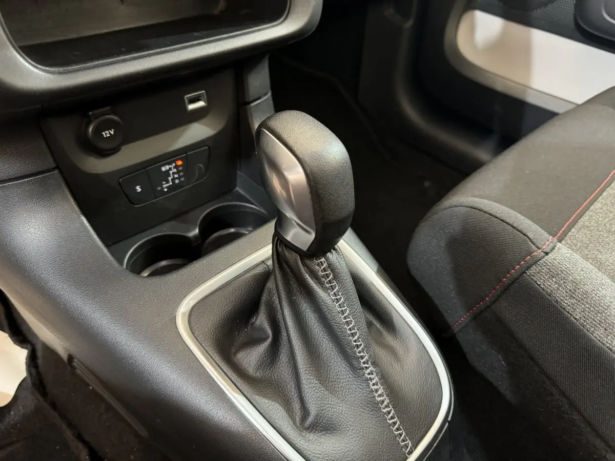 Gros plan sur le levier de vitesse automatique en cuir noir de la CITROEN C3 PureTech 110, avec siège tissu gris et noir adjacent.