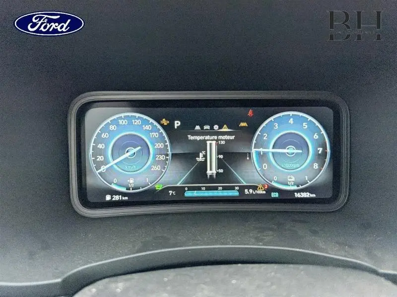Tableau de bord numérique du Hyundai Kona 2021 affichant vitesse, régime moteur et température moteur en vue frontale.