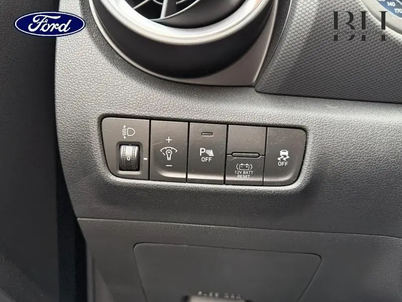 Gros plan sur les commandes de réglage d'éclairage et d'assistance du tableau de bord d'une Hyundai Kona Cyber Grey 2021.