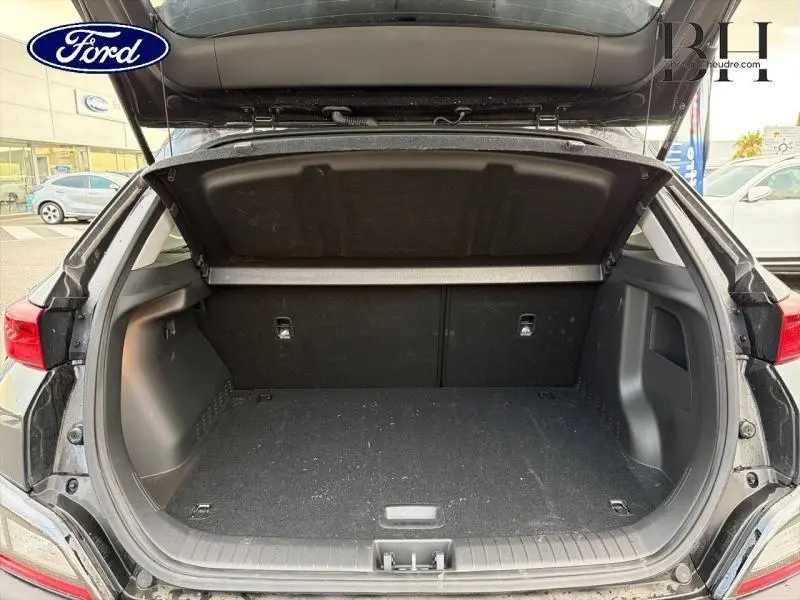 Coffre ouvert en vue arrière d’un Hyundai Kona 1.6 GDi Hybrid Cyber Grey Métal, montrant l’espace de chargement vide.
