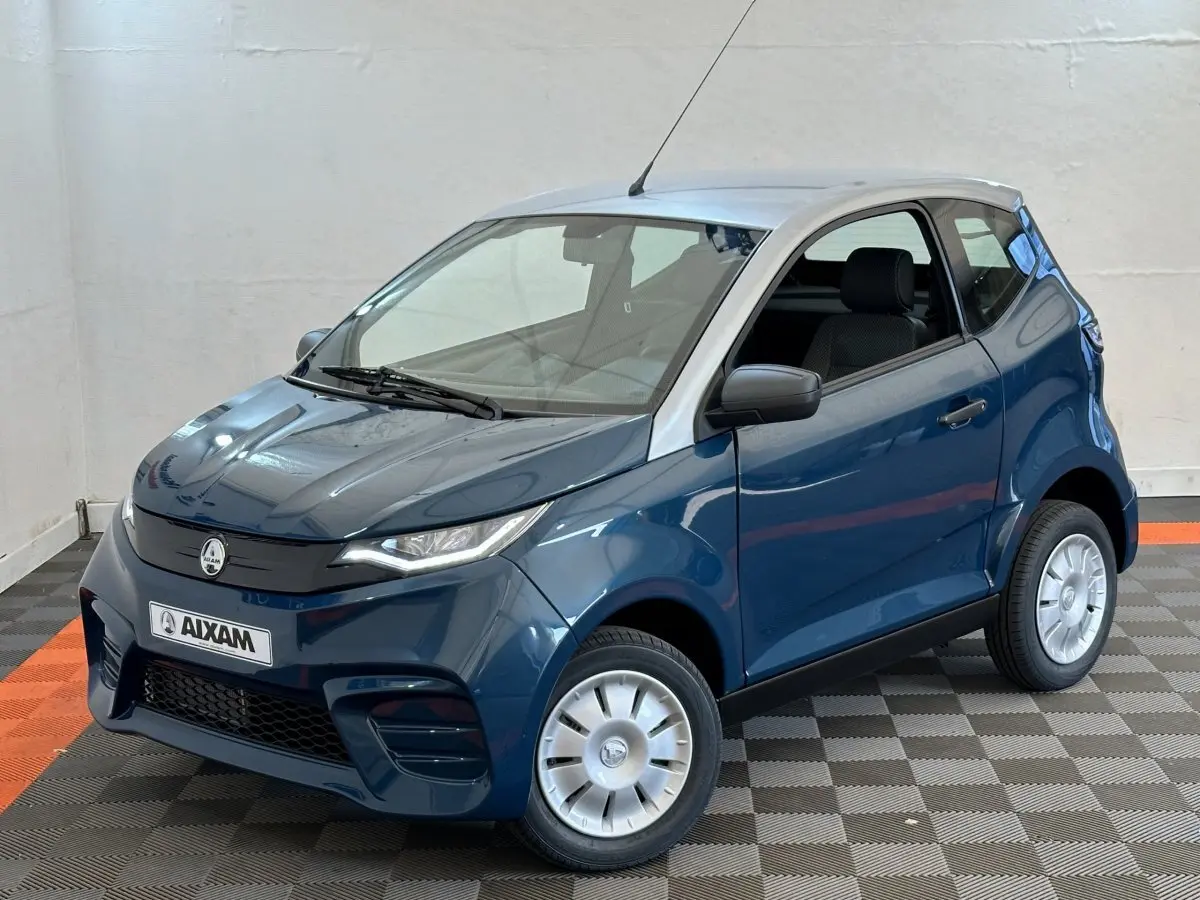 Vue 3/4 avant droite d'une Aixam Ambition 0.5 City Pack bleu avec rétroviseur caméra côté gauche visible.