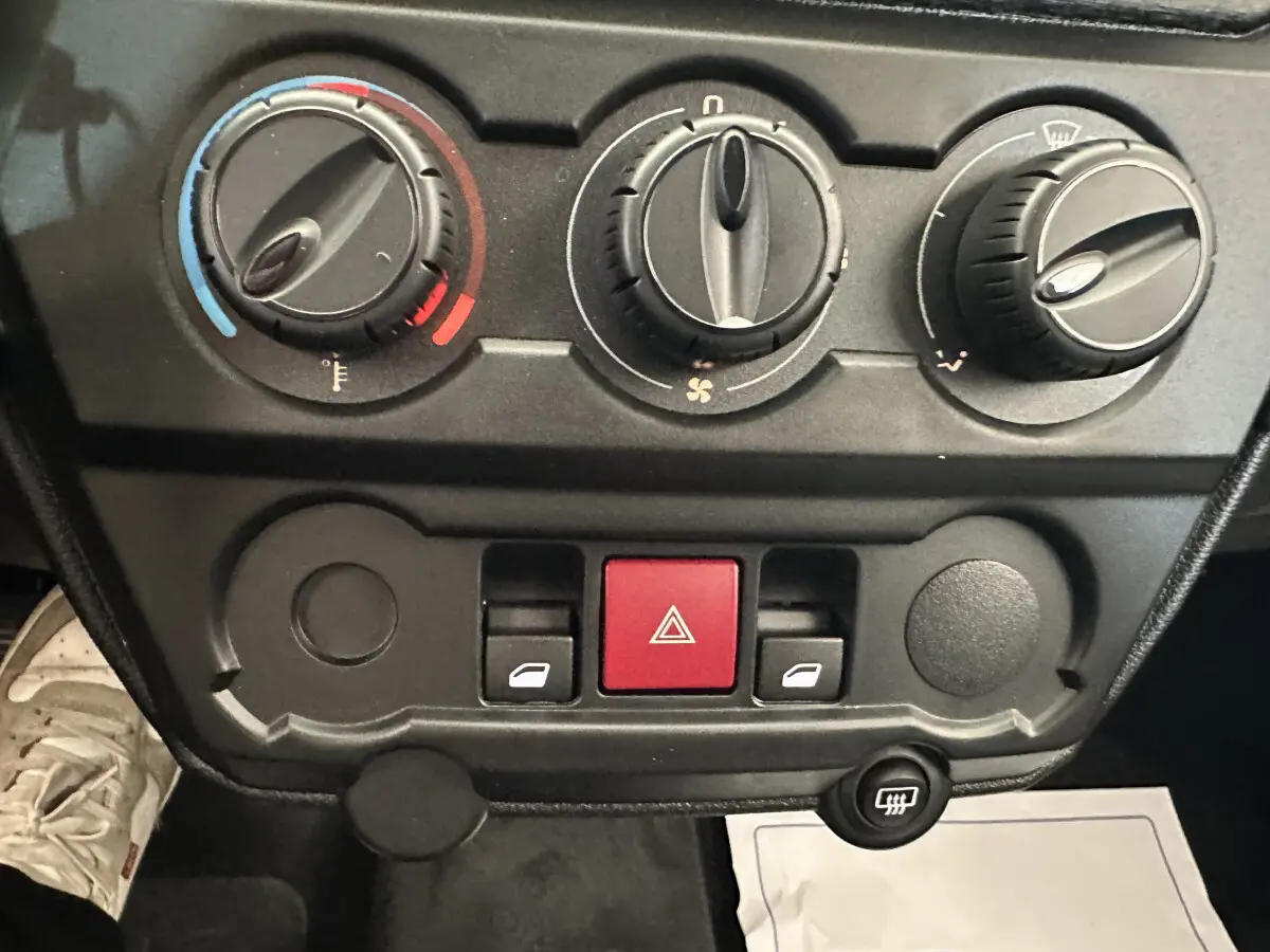 Tableau de bord de l'AIXAM AMBITION 0.5 CITY PACK 2025 montrant les commandes de climatisation et les boutons d'alerte.