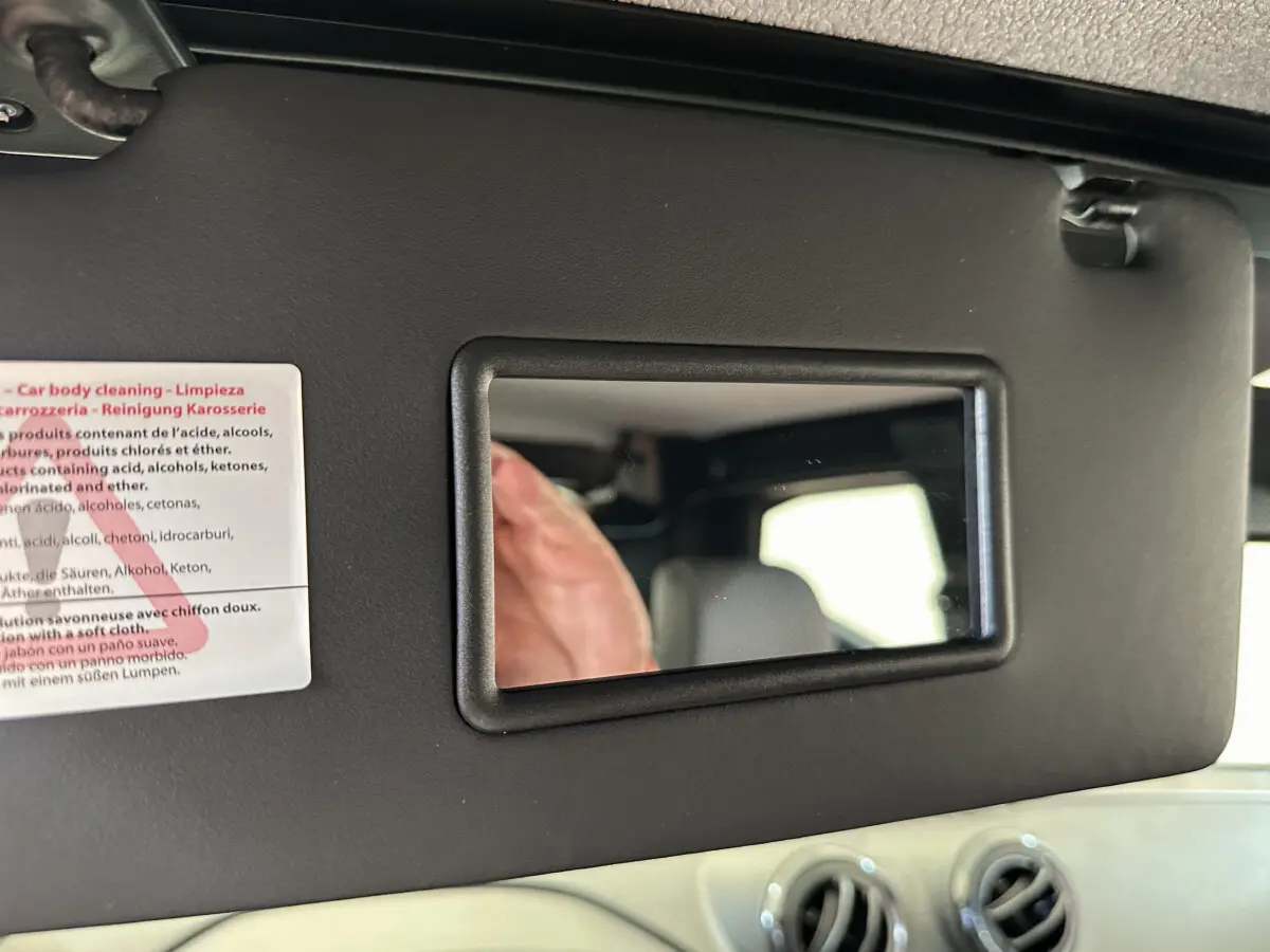 Miroir de courtoisie sur pare-soleil intérieur d'une Aixam Ambition 0.5 City Pack 2025 bleu, avec ventilation visible.