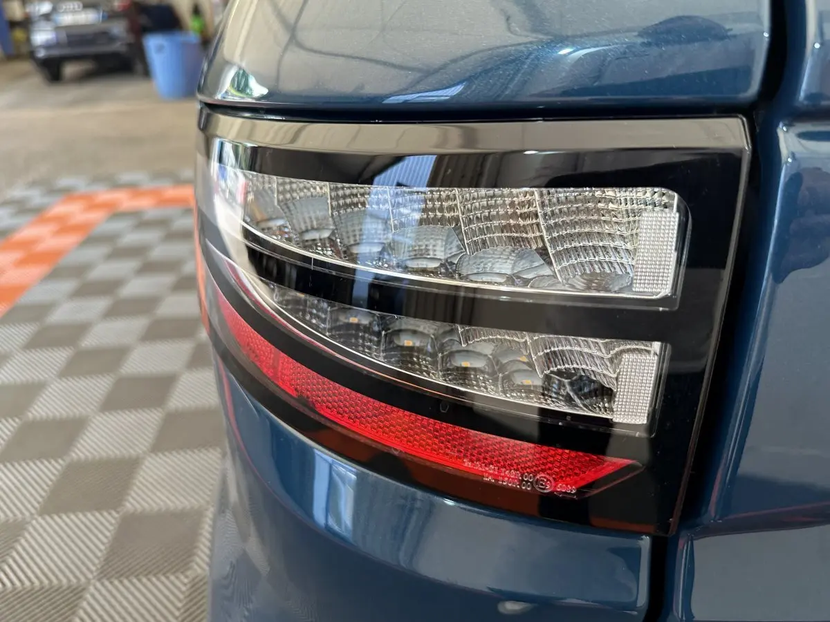 Gros plan sur le feu arrière droit bleu de l'AIXAM AMBITION 0.5 CITY PACK 2025 avec détails lumineux précis.