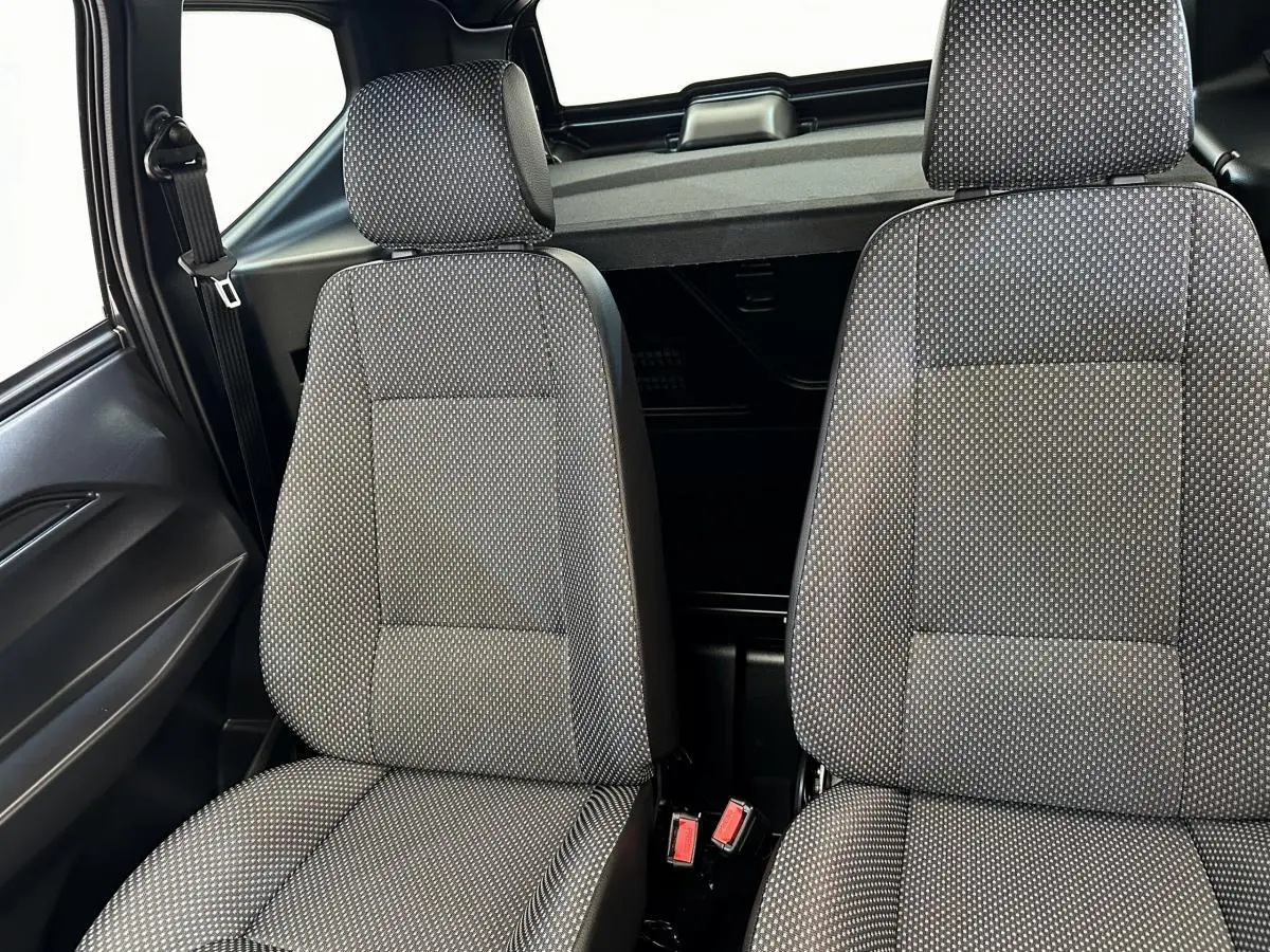 Intérieur montrant les sièges avant gris à motifs de l'AIXAM AMBITION 0.5 CITY PACK 2025, vue rapprochée côté conducteur.