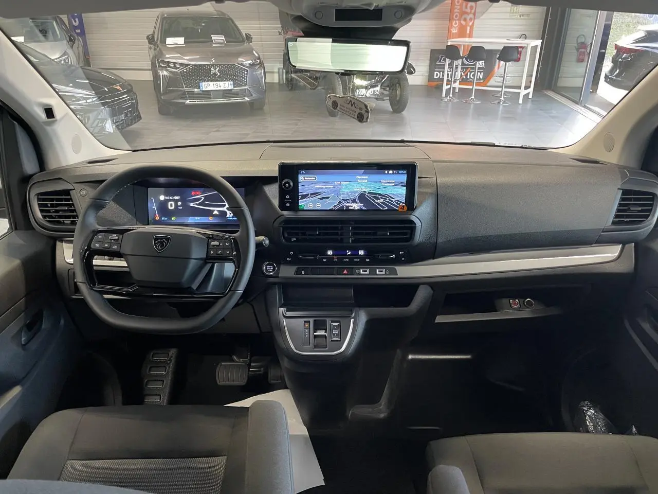 Vue intérieure avant du Peugeot Expert Fourgon 2026, tableau de bord noir avec écran tactile central et volant multifonction.