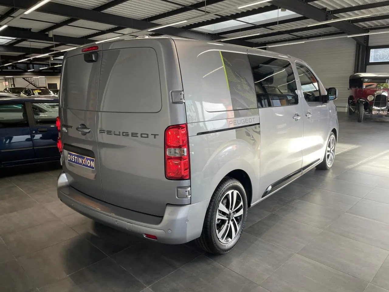 Peugeot Expert Fourgon gris Artense en 3/4 arrière droit, avec jantes alliage et décor latéral noir et vert.