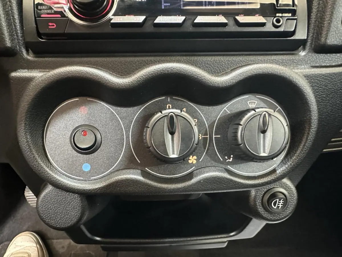 Gros plan sur les commandes de climatisation noires de l'AIXAM MINAUTO E ACCESS 2025 avec réglages manuels et bouton antibrouillard.