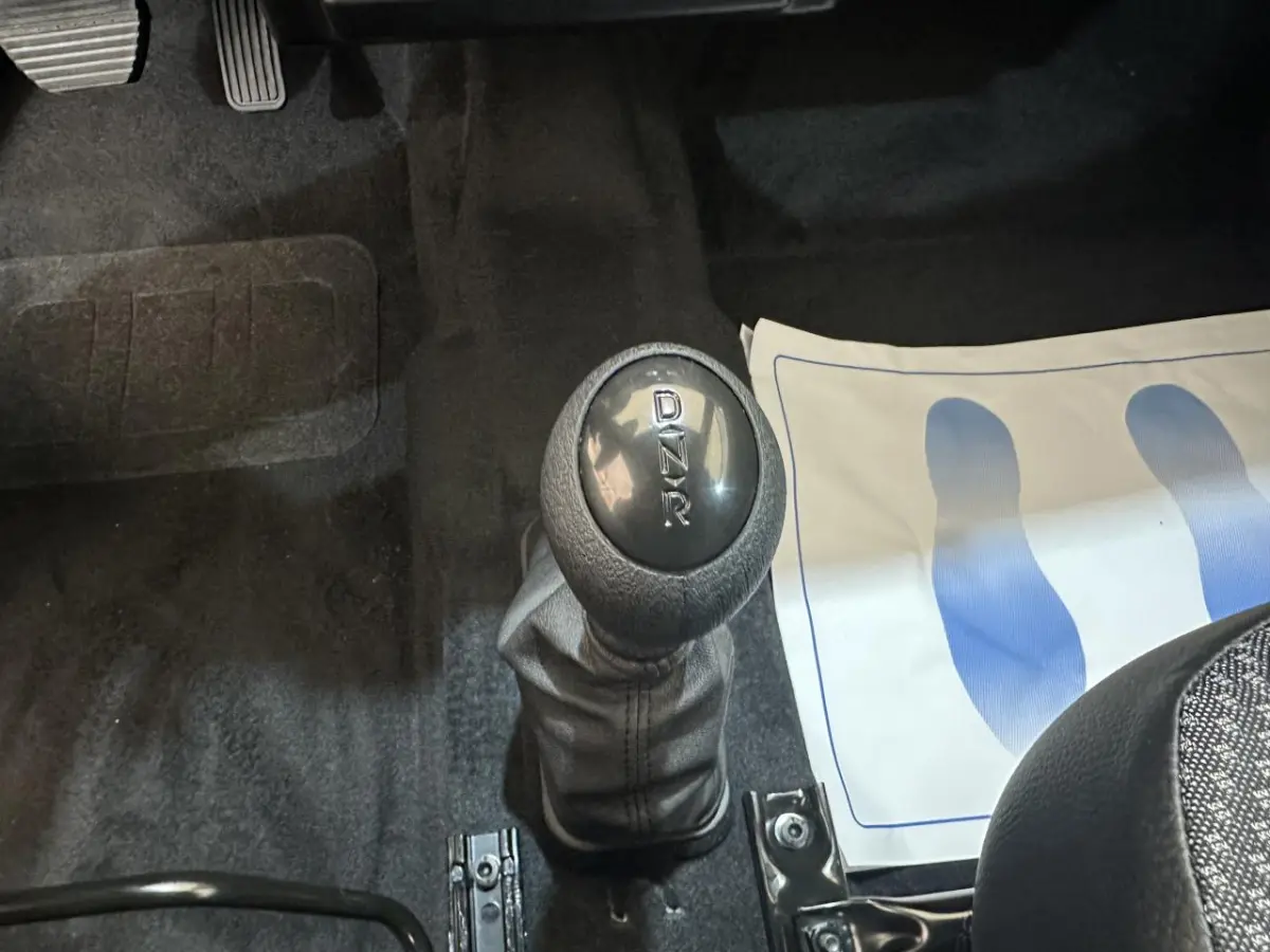 Le levier de vitesses automatique marqué D, N, R dans l'habitacle d'une Aixam MINAUTO E ACCESS blanc, vue rapprochée.