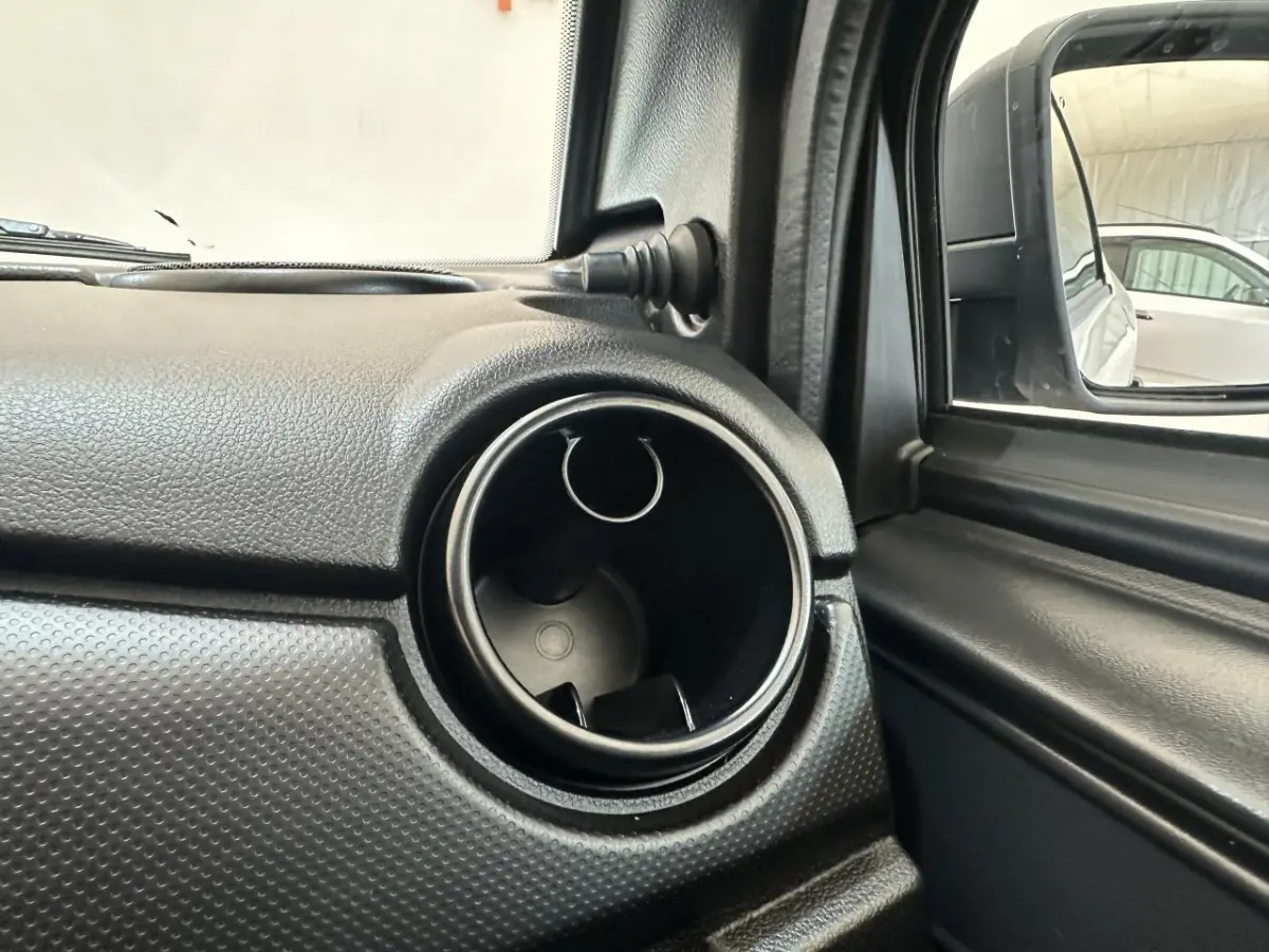 Gros plan sur la sortie d'air ronde côté conducteur de l'AIXAM MINAUTO E ACCESS blanc, avec rétroviseur extérieur équipé d'une caméra.