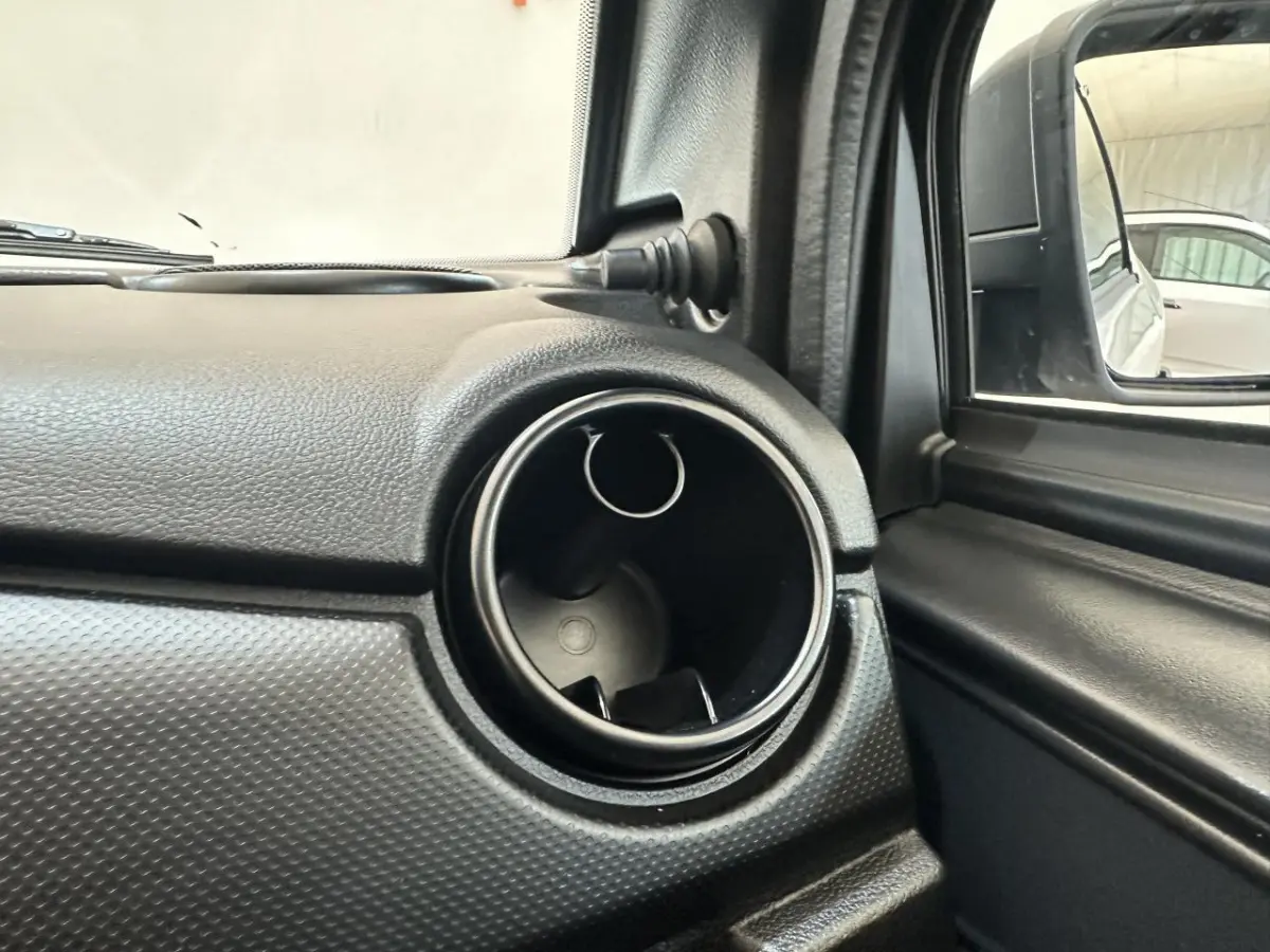 Gros plan sur la sortie d'air circulaire côté conducteur de l'AIXAM MINAUTO E ACCESS blanc, avec rétroviseur extérieur caméra visible.