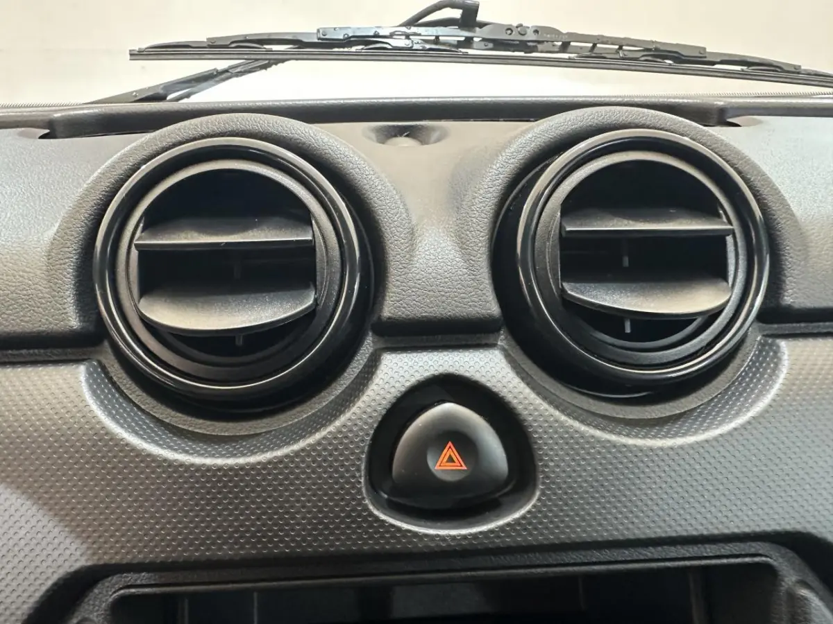 Gros plan sur les aérateurs ronds et le bouton de warning du tableau de bord d'une Aixam MINAUTO E ACCESS blanc 2025.