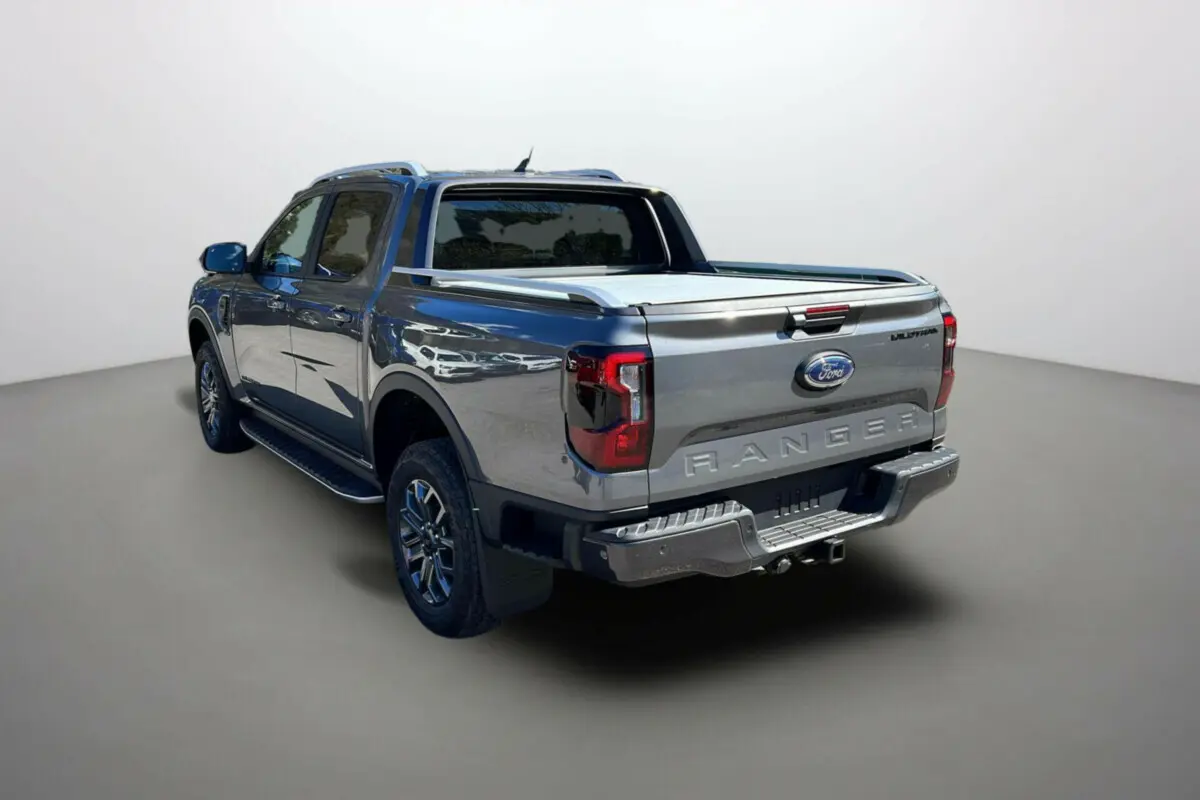 Ford Ranger 2026 gris carbone en 3/4 arrière droit, avec benne couverte et jantes alu 18 pouces visibles.
