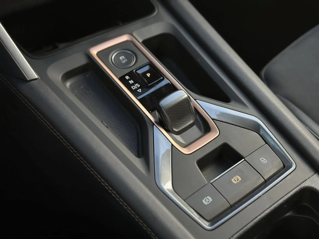 Vue rapprochée de la console centrale noire avec sélecteur de vitesse électronique et commandes du CUPRA Formentor blanc Neige.