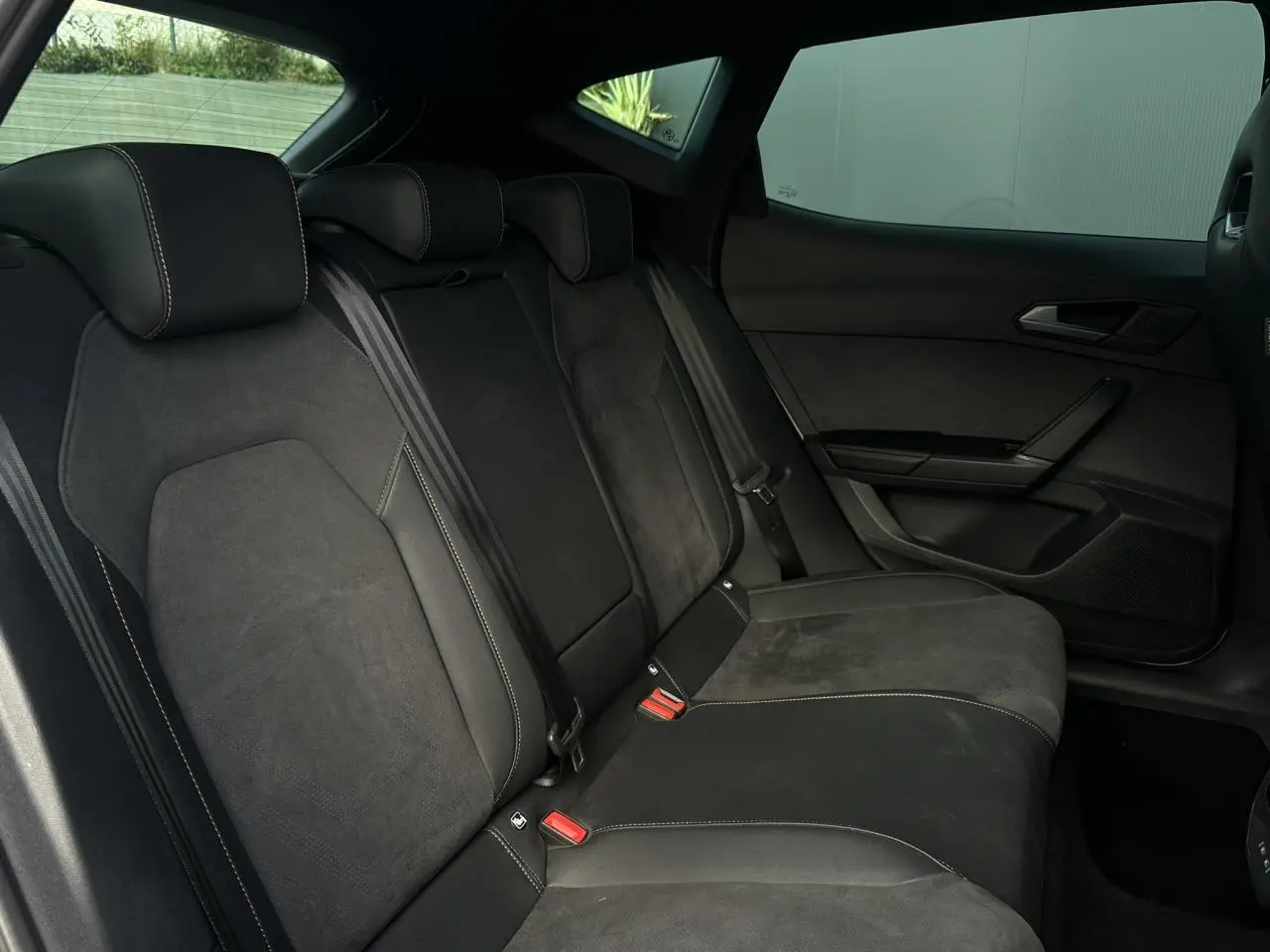 Vue latérale droite de la banquette arrière en cuir et suédine noire du CUPRA Formentor 2025, avec ceintures et appuie-têtes.
