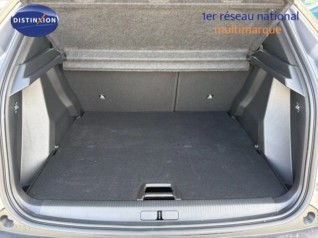 Coffre ouvert en vue arrière d'un Peugeot 2008 gris Artense avec toit noir, montrant l'espace de chargement vide.