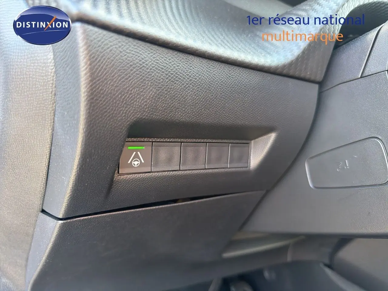 Bouton d'assistance au maintien de voie sur tableau de bord noir du Peugeot 2008 hybride 2026, vue intérieure côté conducteur.