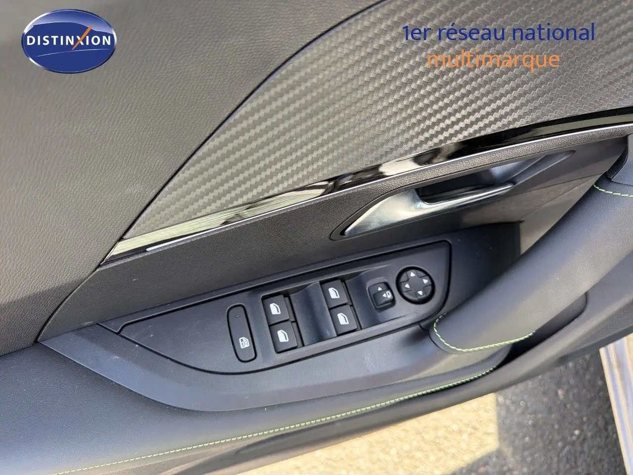 Détail de la porte côté gauche de la Peugeot 2008 1.2 Hybrid 145 GT 2026 avec insert carbone et surpiqûres vertes.